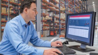 Fleet manager sitting in front of a desktop with Linde connect, the fleet management system from Linde Material Handling Fleet management software